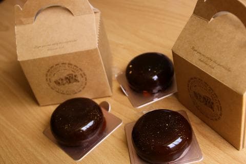 這張「甜點」的照片是三個巧克力蛋糕，放在包裝盒和紙盒上。