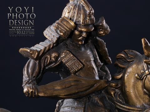 這張照片是一件武士騎馬的雕像，雕像的材質是青銅，武士穿著盔甲，騎在一匹駿馬之上，表情威武，充滿力量感。