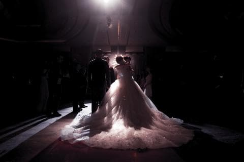 這張照片是一個婚禮的場景，照片的中心是一個身穿白色婚紗的新娘，她與她的新郎站在一起，他們的親朋好友在他們身後。