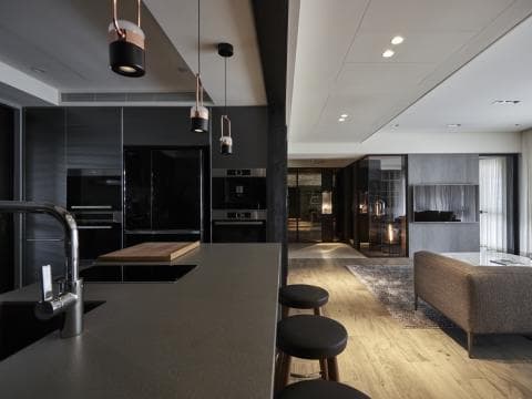 這張照片是一間現代化的廚房，其中最重要的是深色系的大理石流理臺，搭配上簡約的線條，展現出高質感的空間氛圍。