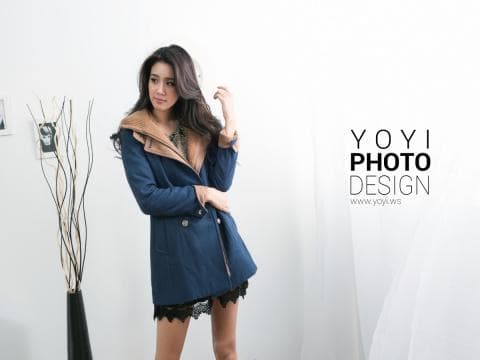 這張「時尚女性」的照片是一個年輕女性穿著藍色外套和黑色裙子的照片，她的眼神堅定，散發著自信的魅力。