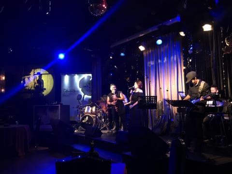 這張照片是一個現場音樂表演的場景，舞臺上有一支樂隊正在演奏。