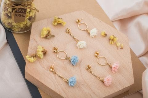 這張「耳環」的照片是六對不同顏色的耳環，分別是藍色、粉色和白色，每對耳環都有一個圓形的金屬環，以及一個毛絨絨的吊墜。