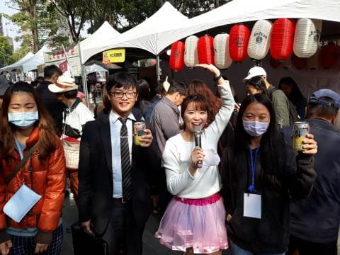 這張照片是一群年輕人在公園野餐，他們在聊天，喝飲料，並且享受陽光。