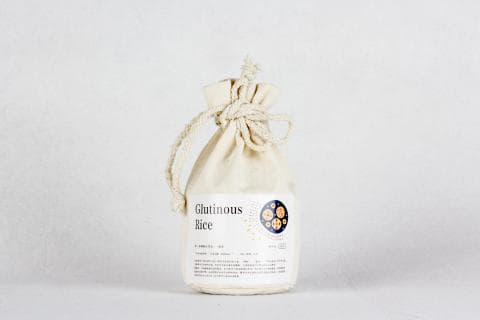 這張「糯米」的照片是一袋用麻布袋裝的糯米。袋子上寫著「Glutinous Rice」，意思是糯米。袋子是用麻繩綁起來的，看起來很簡單樸實。
