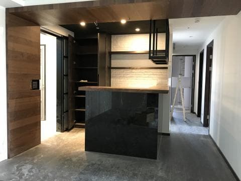 這張照片是一個現代化的廚房，最重要的是黑色的流理台，流理台上有黑色鐵製的架子，看起來很有質感。