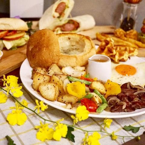 這張「豐盛早餐」的照片是一份包含烤麵包、煎蛋、馬鈴薯、蔬菜和肉片的早餐。