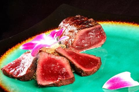 這張「生牛肉」的照片是一盤生牛肉，搭配著一些花瓣裝飾。