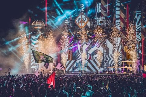 這張「音樂節」的照片是舞臺上充滿煙火和燈光，還有很多觀眾在舞臺前觀看錶演。