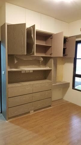 這張照片是一個現代化的廚房，最重要的是一個大型的木質櫥櫃。它有六個抽屜，上面有兩個開放式的層板和一個關閉的門，上面還有兩個較小的櫃子。