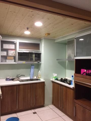 這張照片是一間廚房，最重要的是木頭做成的櫥櫃，上面有烤箱和水槽，以及下方有收納空間，是現代廚房的常見設計。 
