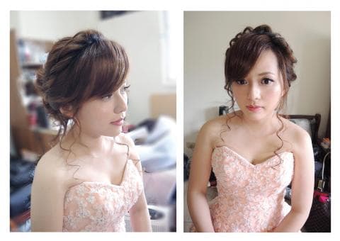 這張照片是一位穿著粉紅色禮服的女性，她的頭髮被精心地盤成一個髮髻，顯得非常優雅迷人。