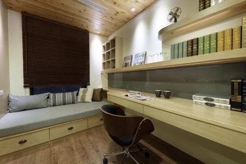 這張照片是房間裡的書桌，桌面光滑整潔，放著一些雜誌和兩杯咖啡，旁邊是木質的層架，上面擺滿了書籍。