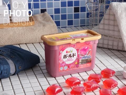 這張「洗衣球」的照片是一盒粉紅色有花朵圖案的洗衣球，旁邊放著一些紅色洗衣球。