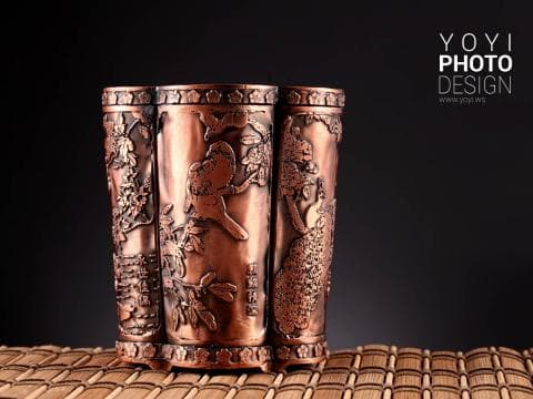 這張照片是一個精緻的銅製容器，表面雕刻著精美的花卉和鳥類圖案，充滿著傳統中國文化的藝術氣息。