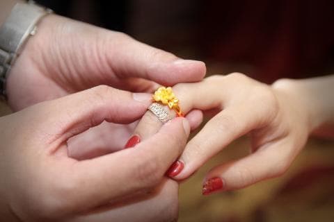 這張照片是一對情侶正在交換戒指，戒指上的鑽石閃耀奪目，象徵著他們堅定的愛情。