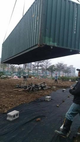 這張照片是一個被吊車吊起的貨櫃，看起來是正在進行一個建築工程。