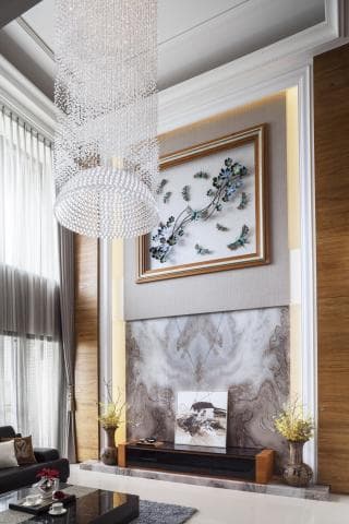 這張「客廳」的照片是一個現代化的家居空間，展示了奢華的裝飾，包括水晶吊燈、大理石壁爐和精緻的傢俱。牆上掛著一幅藝術畫，增添了優雅的氛圍。
