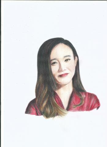 這張照片是一個女性的肖像。她的頭髮是深棕色，長長地披散在肩上。她穿著一件深紅色的衣服，露出了鎖骨。她有一張圓圓的臉，眼睛很大，嘴唇很薄，表情看起來很溫柔。