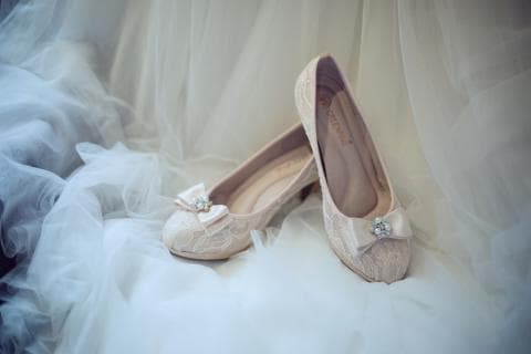 這張照片是一雙美麗的婚鞋，上面有一個閃亮的鑽石蝴蝶結，看起來非常優雅。