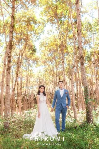 這張照片是一對新人在樹林中結婚，他們穿著婚紗和西裝，笑容滿面，看起來非常幸福。
