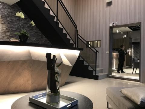 這張「室內設計」的照片是一個現代化的客廳，有一個黑色的樓梯，以及一個黑色的扶手。客廳裡有一個白色的沙發，一個黑色的茶几，以及一個白色的花瓶。牆上有一個鏡子，可以反射客廳的景觀。