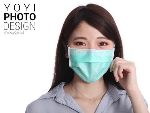 這張「戴著口罩的女性」的照片是一位年輕女子，她戴著藍綠色的口罩，並用手輕輕地扶著口罩。