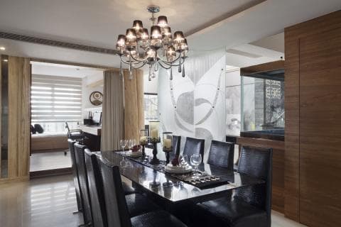 這張「現代化餐廳」的照片是一個開放式空間，有黑色的餐桌和椅子，以及一個華麗的水晶吊燈。牆上是木質裝飾，以及一個透明的隔板，讓整個空間顯得更加寬敞明亮。