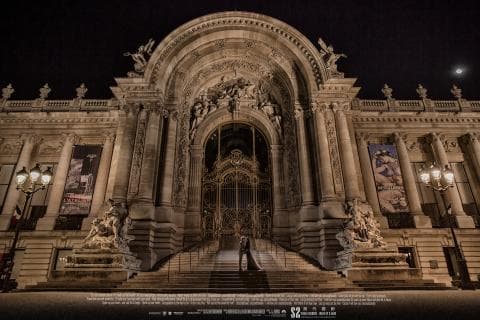 這張照片是一棟宏偉的建築，有著高聳的拱門和精美的雕刻，以及一對站在門前的新人。