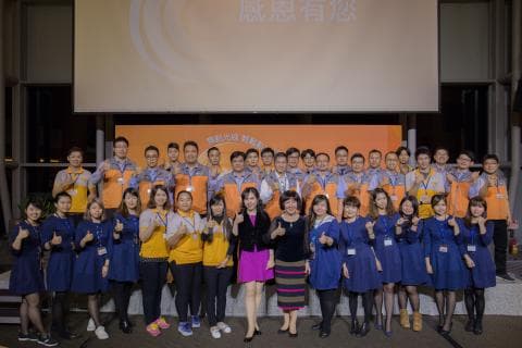 這張「一群人合照」的照片是一個團隊的合照，裡面有男女老少，他們都穿著整齊的服裝，站在一起，看起來很和諧。