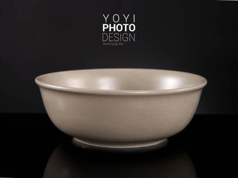 這張照片是一個淺色的碗，放在黑色的背景上。碗的形狀很簡單，顏色很柔和，材質看起來很光滑。