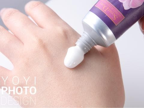 這張照片是一隻手正在塗抹乳液，重點是乳液正被擠出，形成一個圓形的白色液體。