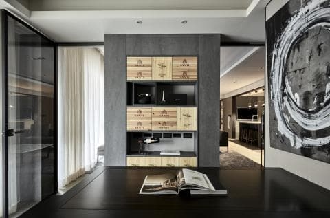 這張照片是一張簡約現代的室內設計，最顯眼的地方是牆上的一幅抽象畫。它以黑色為底，上面用白色塗料繪製了一個旋轉的圓形圖案，展現出獨特的藝術風格。