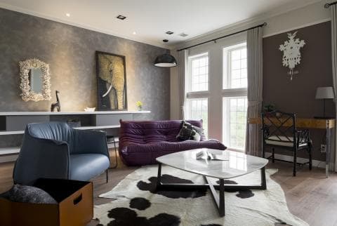 這張「現代風格客廳」的照片是一間寬敞明亮的客廳，有著大型落地窗和舒適的沙發，以及一張精緻的咖啡桌。牆壁上掛著藝術作品和裝飾品，讓整個空間充滿藝術氣息。