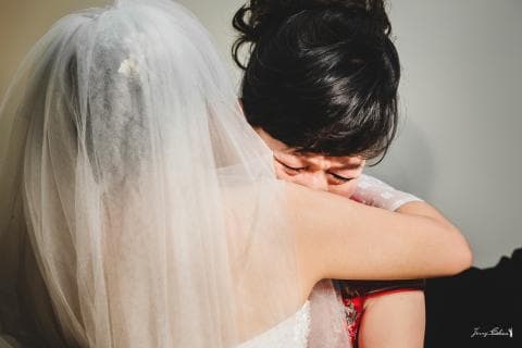 這張「婚禮」的照片是一對新人在婚禮上擁抱，新娘戴著頭紗，新郎擁抱著新娘，新娘眼角泛淚。