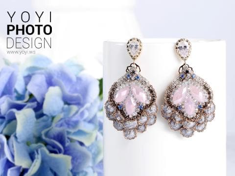 這張照片是一對精緻的耳環，耳環上鑲嵌著粉色和藍色寶石，以及金色和銀色的裝飾，整體設計精緻優雅，令人賞心悅目。