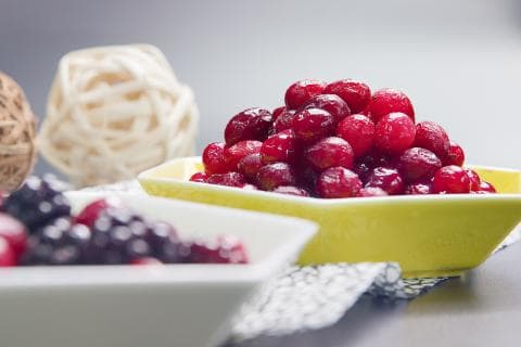 這張照片是盛滿紅色的果醬的黃色碗，看起來美味可口。