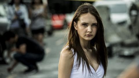 這張「一位年輕女子站在街頭，看著鏡頭，表情嚴肅」的照片是。