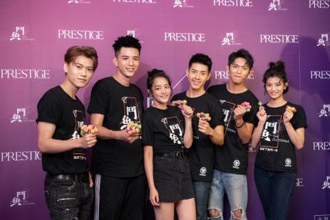 這張「演員合照」的照片是五位年輕演員，他們穿著黑色 T 恤，上面印著戲劇名稱，並在背景牆上擺出姿勢，手裡拿著零食。