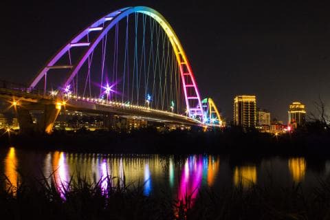 這張「彩虹橋」的照片是夜晚的橋樑，橋上裝飾著五彩繽紛的燈光，映照在河面上，非常漂亮。