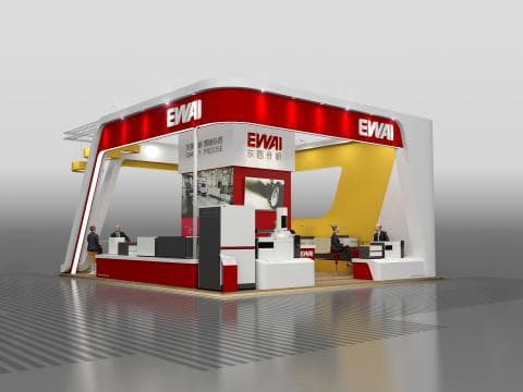 這張「展覽攤位」的照片是一個紅色的展覽攤位，上面有「EWAI」的字樣。攤位上有兩個工作人員和一些產品展示。