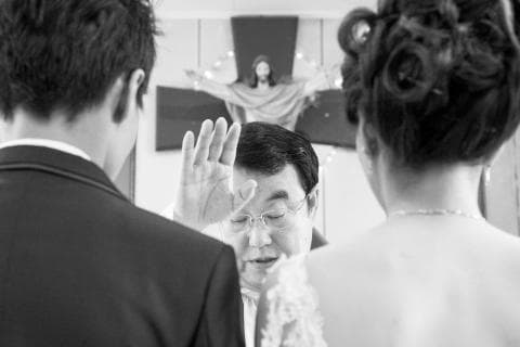 這張「婚禮」的照片是兩個新人正在教堂舉行婚禮，神父正在為他們主持儀式。