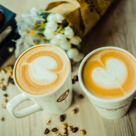 這張照片是兩杯熱騰騰的咖啡，咖啡上都有美麗的愛心圖案。