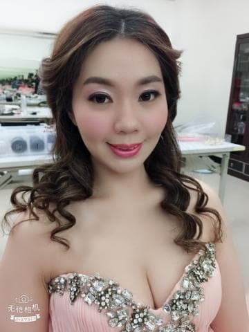 這張「婚紗照」的照片是一個美麗的女性穿著粉紅色婚紗，她有著迷人的笑容和精緻的妝容，並且配戴著閃亮的珠寶。