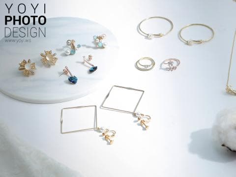 這張「飾品」的照片是一些金色的耳環、戒指和手環，它們都擺放在一個白色背景上。