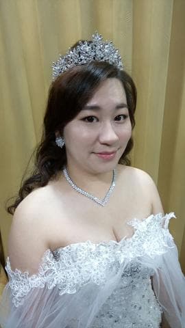 這張「新娘」的照片是一個穿著白色婚紗，戴著皇冠和項鍊的新娘，她看起來很美麗。