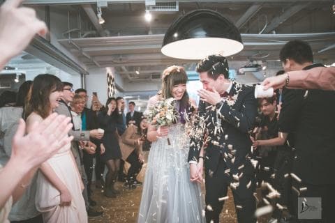 這張照片是一對新人在婚禮上被親友們撒著彩帶祝福，他們都笑得很開心，看起來非常幸福。
