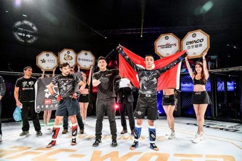 這張照片是八位拳擊選手站在拳擊場的中心，其中最中間的兩位選手正在舉著獎盃，並準備拍照留念。