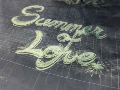這張照片是夏季的英文單詞“Summer of Love”的字體設計，採用的是線條描繪的方式，字跡飄逸瀟灑，帶有一種自由奔放的感覺。