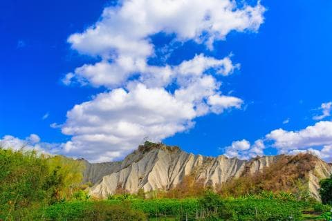 這張「山脈與白雲」的照片是藍天白雲下的壯麗山脈，山勢險峻，雲朵飄逸，景色壯觀。